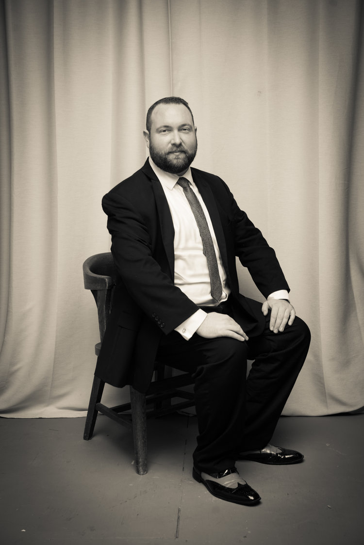 A man sitting on a chair in the middle of a room with fancy shoes.